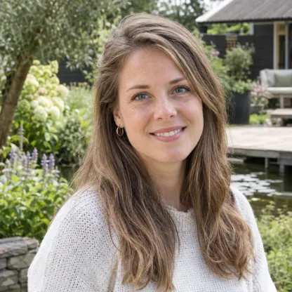 Portret van een lachende vrouw met halflang haar in een tuin