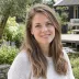 Portret van een lachende vrouw met halflang haar in een tuin